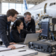 Aerospace engineers reviewing an avionics test station in an aircraft hangar