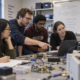 University researchers collaborating in an electronics teaching laboratory