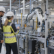 Industrial engineers inspecting a connected factory cell with wireless sensors