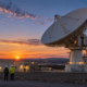 Satellite ground-station dish and operations facility at twilight