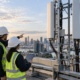 Telecommunications engineers inspecting cellular antenna infrastructure on a city rooftop